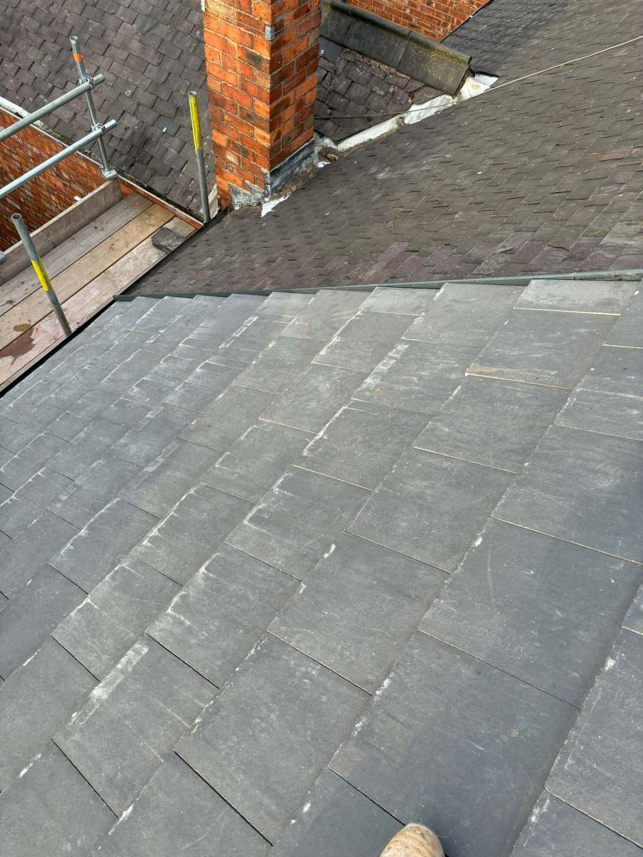 New slate tiles dressed into a brick chimney with fresh lead flashing